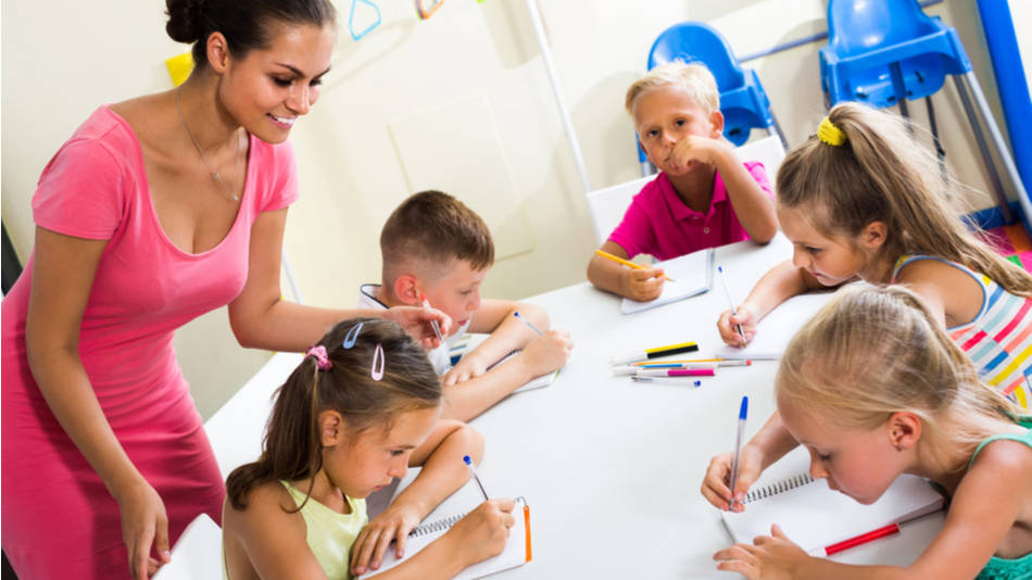 maestra enseñando a los niños en el cole