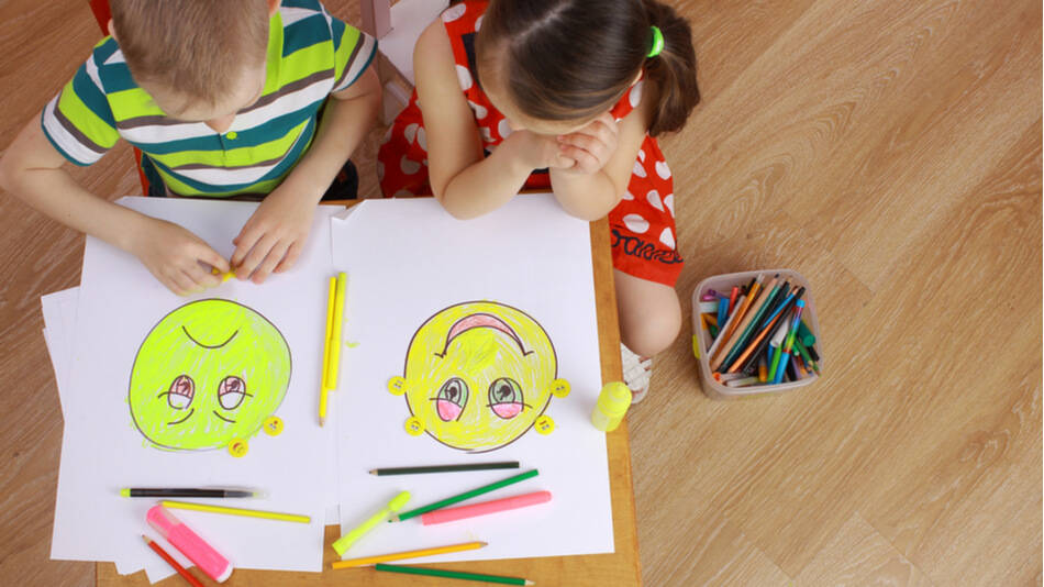 dos niños mirando las caritas que han pintado