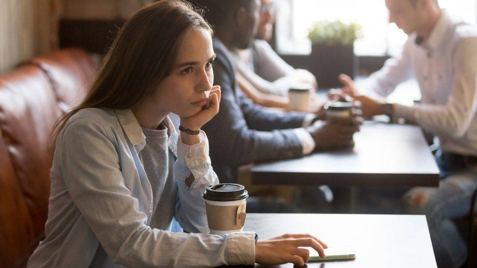 Chica sola en cafetería, que no quiere entablar amistad con nadie por sufrir un trastorno de la personalidad por evitación