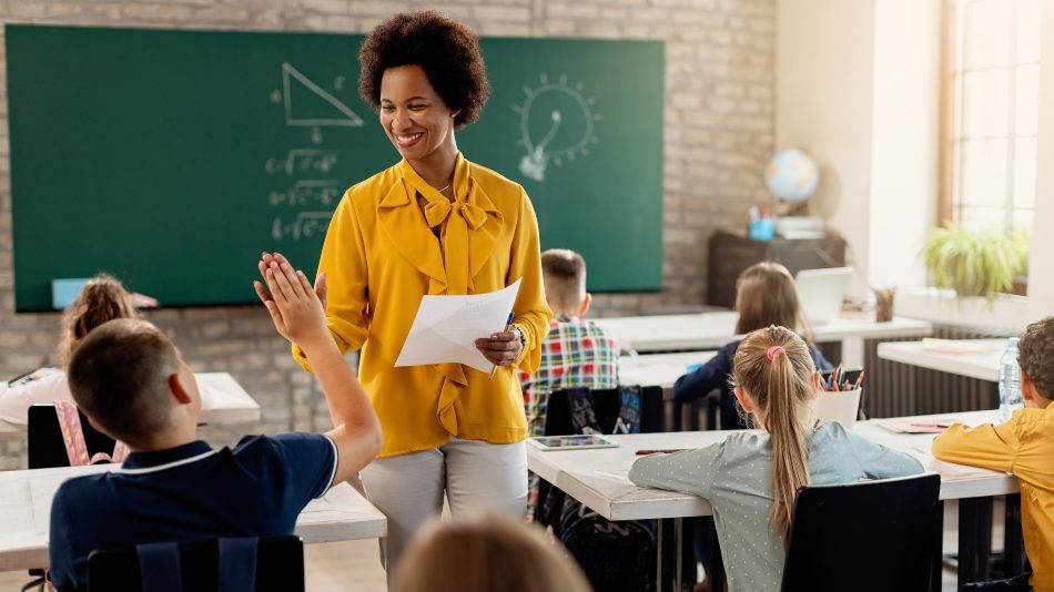 Buenas prácticas de educación inclusiva - maestra y alumno chocando la mano