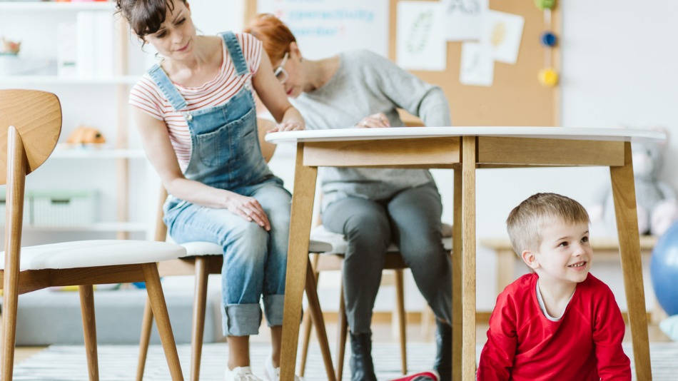 aula niño debajo de la mesa