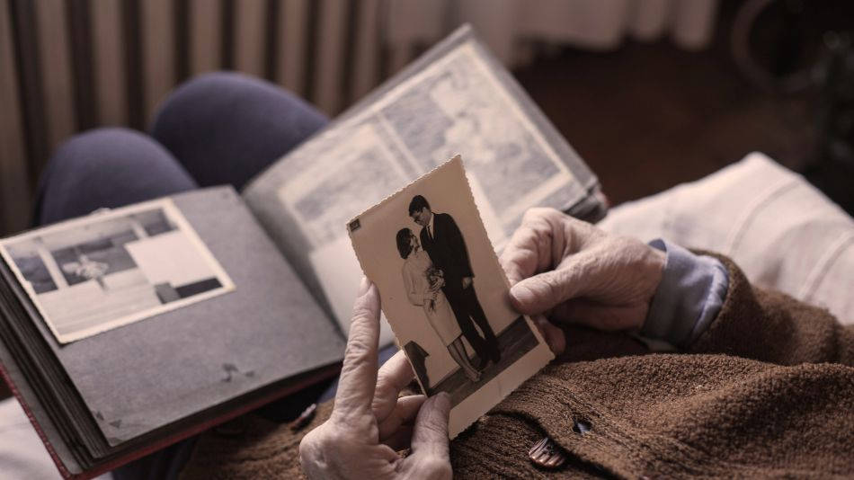 persona mayor con foto reviviendo el pasado a través de una terapia de reminiscencia